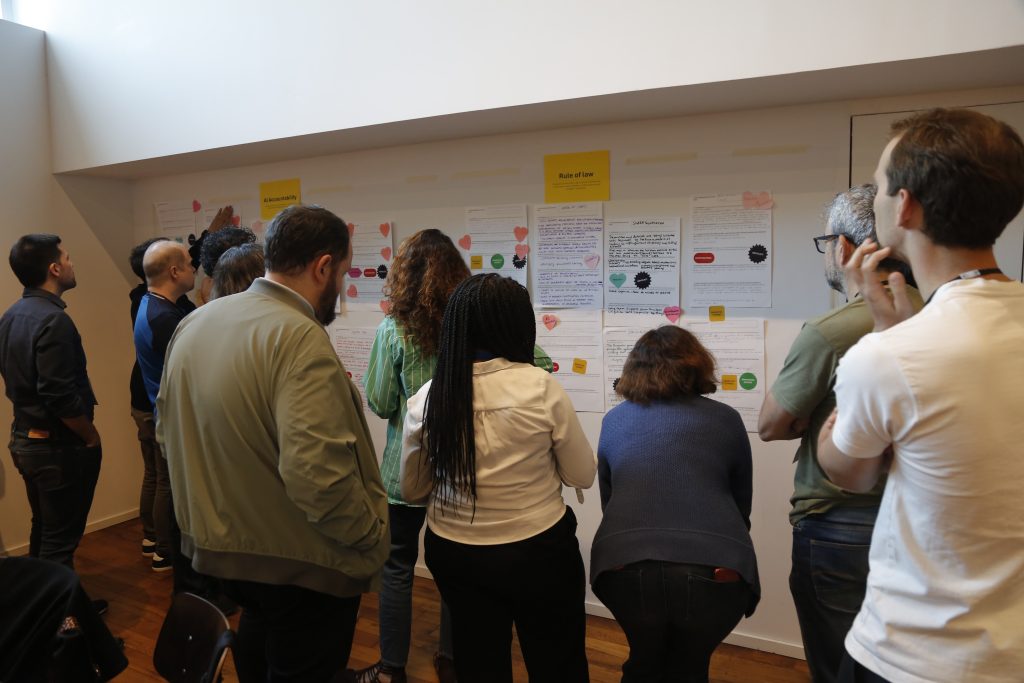 People in a workshop in front of post it notes and posters